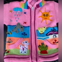 a child's pink sweater with animals on it