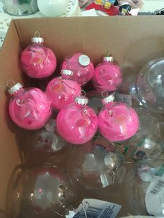 a box filled with pink ornaments on top of a table