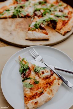 two slices of pizza sitting on top of white plates