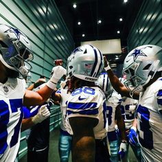 some football players are lined up in the locker room for their team's game