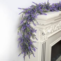 purple flowers are growing on the fireplace mantel