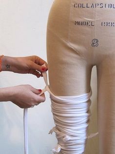 a woman is working on her leggings with tape