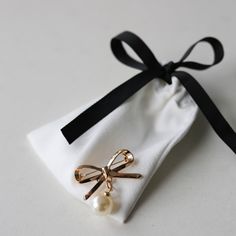 The Bow Brooch is here! Add this sweet classic pin to your any piece of clothing. The gold bow with a drop pearl is a great addition to any outfit. Wear this timeless brooch on a sweater, a blazer lapel, a dress or any top to give your outfit a little something extra. Approximately 1.25" x 1.125" Gift Bow Brooch, Gold Wedding Brooches Chic Style, Chic Gold Wedding Brooch, Gold Chic Wedding Brooches, Chic Gold Wedding Brooches, Gold Wedding Brooches In Chic Style, Chic Gold Brooches For Party, Classic Wedding Brooch With Bow, Elegant Gold Brooches With Ribbon