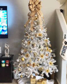 a white christmas tree with gold and silver ornaments