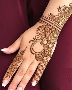 a woman's hand with henna tattoos on it