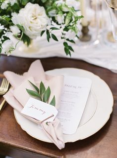 a place setting with napkins, silverware and flowers