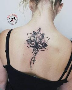 a woman with a black and white tattoo on her back shoulder, showing the lotus flower