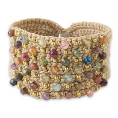 a crocheted bracelet with multi colored beads and gold accents on the outside of it