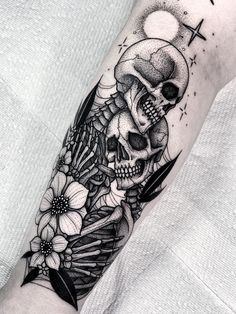 a black and white skull with flowers on it's arm