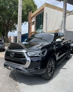 a black toyota pickup truck parked in front of a building