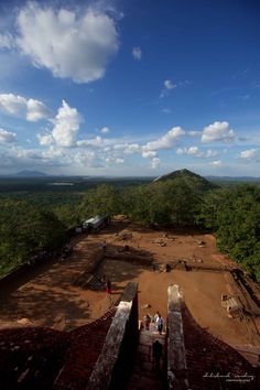 people are standing at the top of a building in front of some trees and mountains