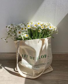 a bag filled with daisies sitting on top of a wooden floor