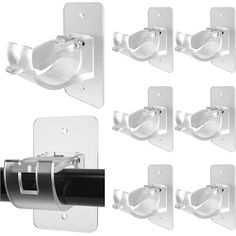 six white wall mounted toilet paper dispensers with one black and one white holder