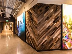 a large wooden wall in the middle of a hallway with paintings on it's sides