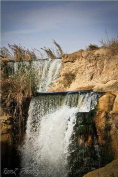 the water is running down the side of the waterfall