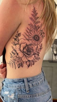 a woman's back with flowers and leaves on it