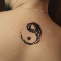 a person with a tattoo on their back that is shaped like a yin - yang symbol