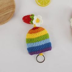 a crocheted hat with a fruit on top and a keychain attached to it