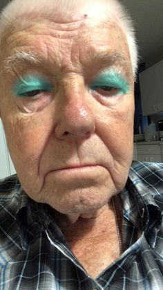 an older man with blue eyes and white hair is looking at the camera while wearing a checkered shirt