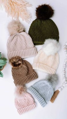 six knit hats with pom - poms on them