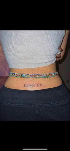 a woman's stomach with the words forever you tattooed on her lower back side