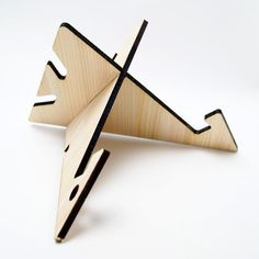 a wooden object that looks like an airplane with black stripes on the bottom and sides