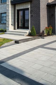 a brick house with steps leading up to the front door and side entry area, on a sunny day