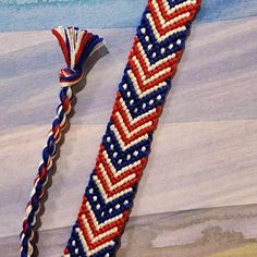 two red, white and blue braided bracelets with tassels on them