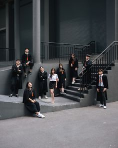 a group of people standing on top of steps next to each other in front of a building