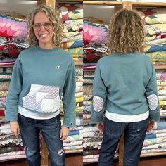 a woman standing in front of stacks of quilts