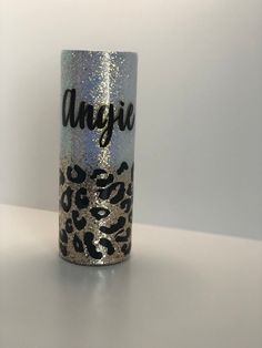 a silver and black cup with an animal print on the bottom that says, anasia