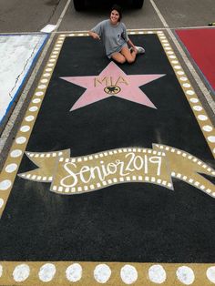 a woman sitting on the ground in front of a star