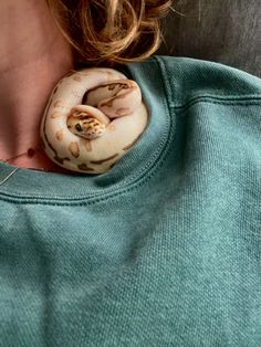 a close up of a person wearing a green shirt with a snake on it