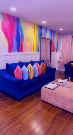 a living room filled with blue couches and colorful walls