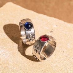 two silver rings with red and blue stones