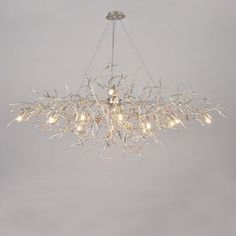 a chandelier hanging from the ceiling in a room with grey walls and flooring