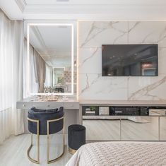 a bedroom with marble walls and flooring in the background, there is a large mirror on the wall