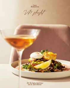 a white plate topped with food next to a glass of wine