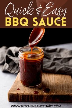 a jar filled with bbq sauce sitting on top of a cutting board next to a spoon