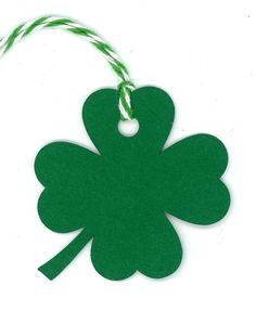 a green shamrock shaped ornament hanging from a string