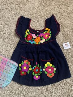 "12 months, Beautiful & Authentic Mexican Girls Dress, very fresh and light weight made with cotton blend fabric. All embroidered work is Handmade, just gorgeous and unique.... Size: 12 Months Care Details: Hand wash only, Hang dry Measurements: 17\" long 11\" waist Great for any celebrations or good for a sunny birthday party as well. Don't wait till the last minute and email me TODAY.... All of my items come from a smoke and pet free environment. Please email me your questions before buyin Cute Cotton Embroidered Short Sleeve Dress, Cute Embroidered Short Sleeve Cotton Dress, Spring Cotton Embroidered Dress With Machine Embroidery, Cotton Embroidered Dress With Machine Embroidery For Spring, Multicolor Cotton Embroidered Dress With Border, Blue Cotton Dress With Floral Applique, Spring Cotton Dress With Embroidered Border, Summer Cotton Dress With Machine Embroidery, Cotton Summer Dresses With Machine Embroidery