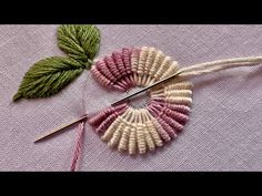 a pair of scissors sitting on top of a piece of fabric next to a needle