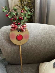 a reindeer head on top of a stick with red berries and greenery sticking out of it