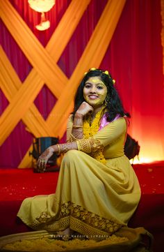 a woman sitting on the ground in a yellow dress