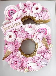 there is a pink and white wreath made out of donuts