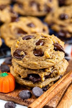 chocolate chip cookies stacked on top of each other next to cinnamon sticks and pumpkins