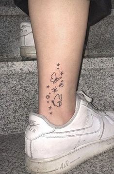 a woman's foot with a small tattoo on it