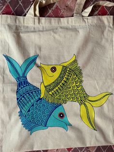 a tote bag with two fish painted on it