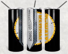 two black cans with yellow and white designs on them are next to each other in front of a gray background