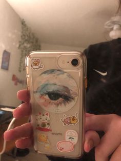 someone holding up their phone case with stickers on it